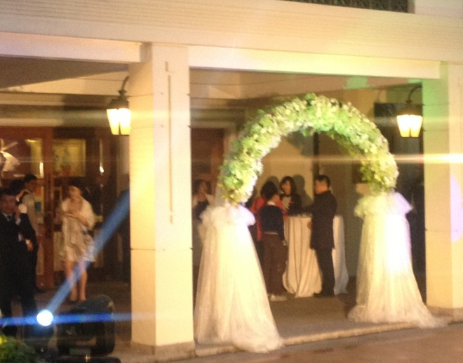 Cổng hoa của tiệc cưới gồm 2 màu trắng và xanh rất nhẹ nhàng, dễ thương. Từ hơn 17h, quan khách lần lượt có mặt dù theo tiệp mời, 18h hôn lễ mới chính thức bắt đầu. 