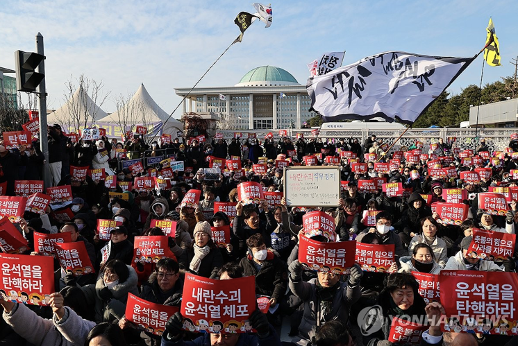 Đám đông biểu tình trước trụ sở Quốc hội Hàn Quốc trước phiên bỏ phiếu về kiến nghị luận tội, ngày 7/12. (Ảnh: Yonhap)