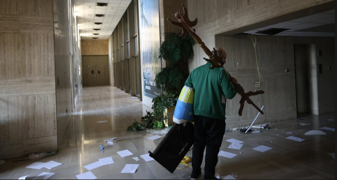 Một người lấy đồ nội thất từ dinh tổng thống. (Ảnh: EPA)