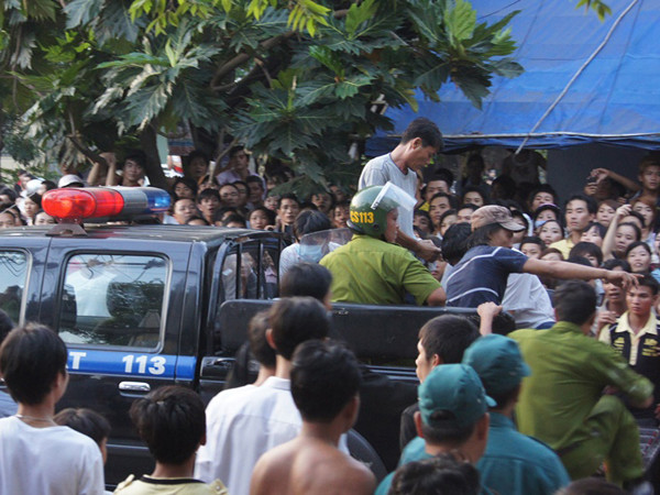 Lực lượng chức năng áp giải Bình lên xe 