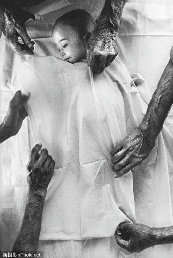 2001: Người ta đang liệm cho một em bé Afghanistan tị nạn trên đất Pakistan. Em đã chết vì mất nước và kiệt sức