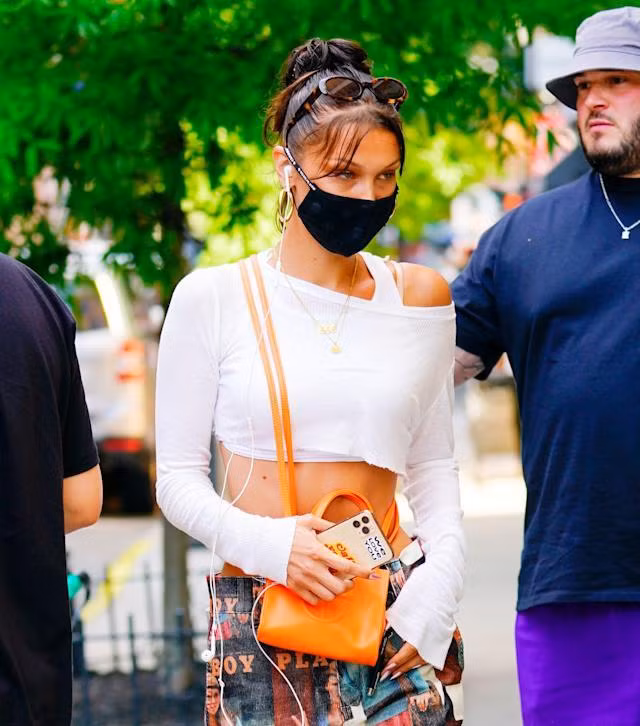 Người mẫu Bella Hadid dạo phố cùng mẫu túi Telfar màu cam đeo chéo.