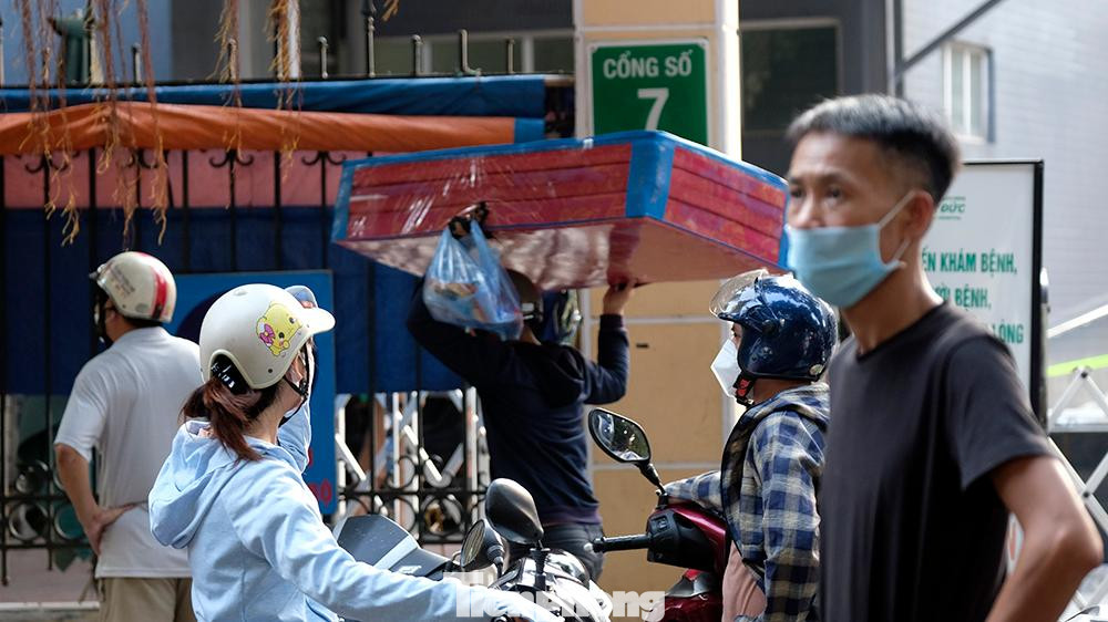Bên ngoài khu vực cổng, người nhà bệnh nhân nháo nhác chuẩn bị tiếp tế đồ đạc cho người thân.