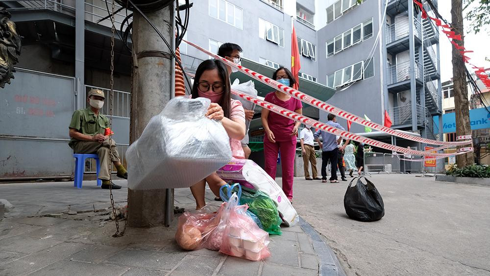 Người dân chuẩn bị nhu yếu phẩm thiết yếu sau khi hay tin toà nhà bị phong toả.