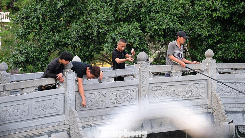 Không một ai trong tốp thanh niên câu cá ở Hồ Tây đeo khẩu trang phòng dịch.