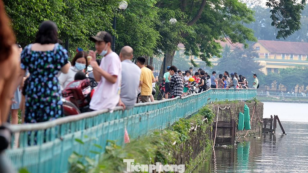 Không gian phía đối diện, hàng trăm người đứng hàng dài thưởng thức kem dưới thời tiết oi bức của Hà Nội những ngày đầu hè.