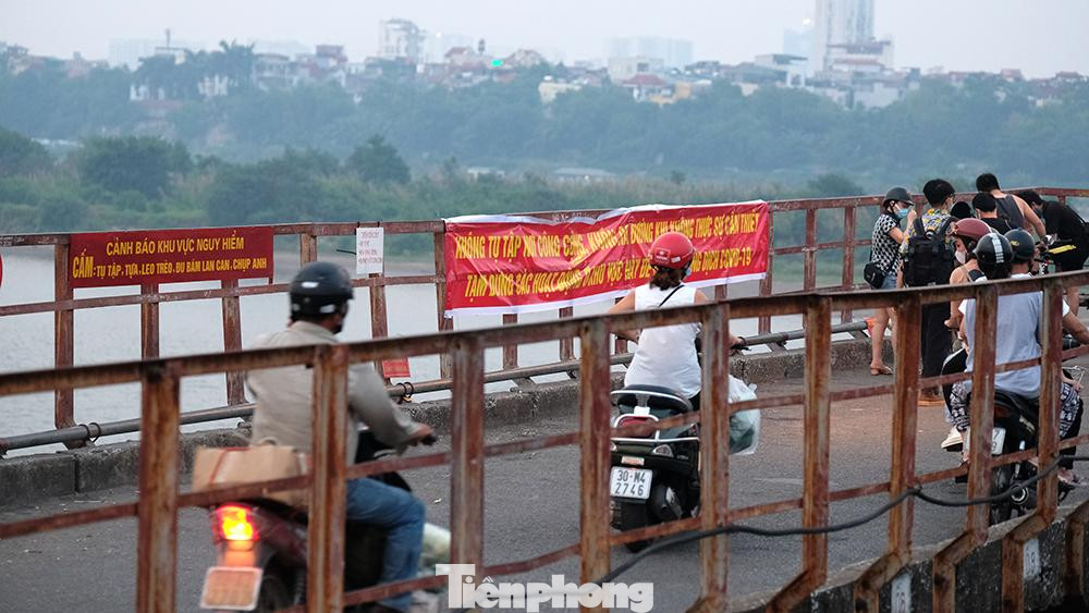 Ngay gần biển cảnh báo "Không tụ tập nơi công cộng..." là nhóm bạn trẻ tụ tập... chụp ảnh cho nhau.