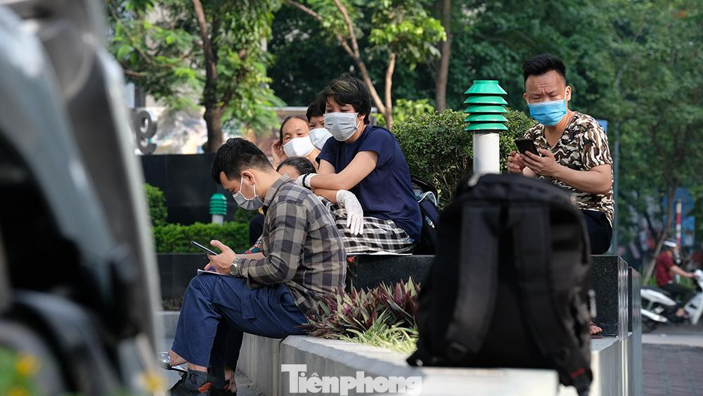 Nhân viên làm việc trong tòa nhà đợi chờ thông tin để được lên công ty làm việc vào đầu giờ sáng nay.