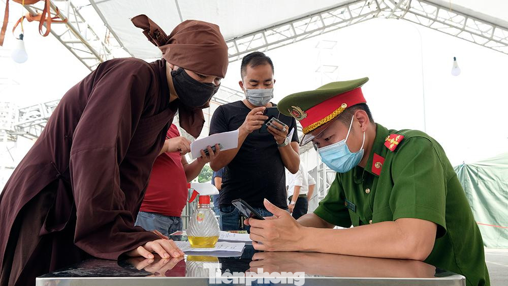 Tất cả người trên xe đều phải xuống để quét mã QR khai báo y tế. Một số người phải nhờ các chiến sĩ công an hỗ trợ khai báo giúp qua điện thoại. Tất cả người trên xe đều phải xuống để quét mã QR khai báo y tế. Một số người phải nhờ các chiến sĩ công an hỗ trợ khai báo giúp qua điện thoại.