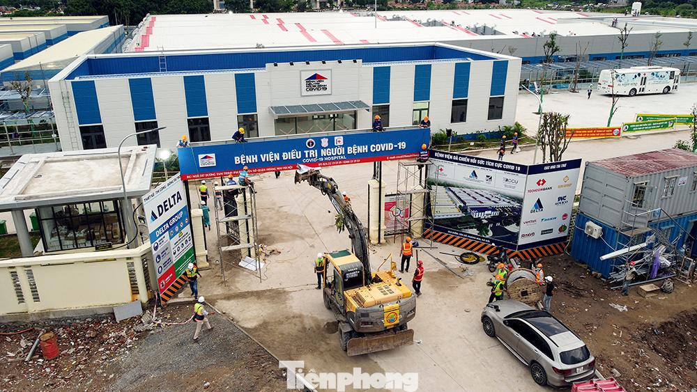 Công nhân đang tiến hành lắp đặt biển bệnh viện tại cổng chính.