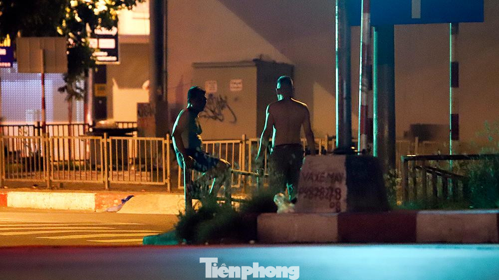 Tập thể dục trên vỉa hè bên sông Tô Lịch gần khu vực Cầu Giấy lúc 4 giờ sáng nay (7/8).