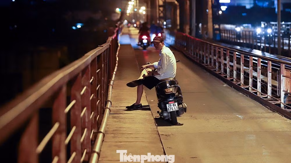 Dựng xe trên cầu, không đeo khẩu trang ngồi hóng gió.
