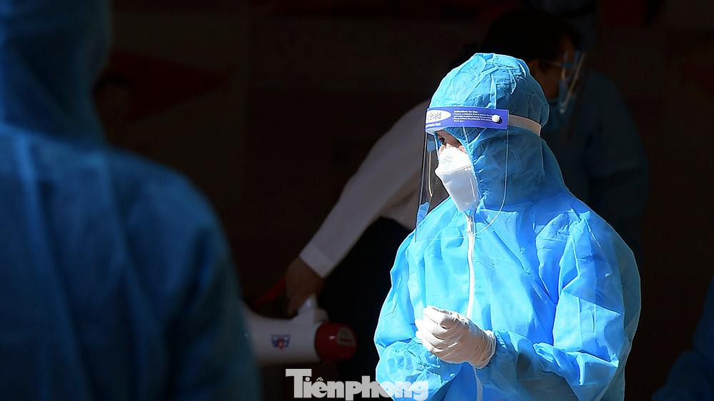 Nhân viên y tế trong bộ đồ bảo hộ kín mít dưới thời tiết oi nóng của Hà Nội.