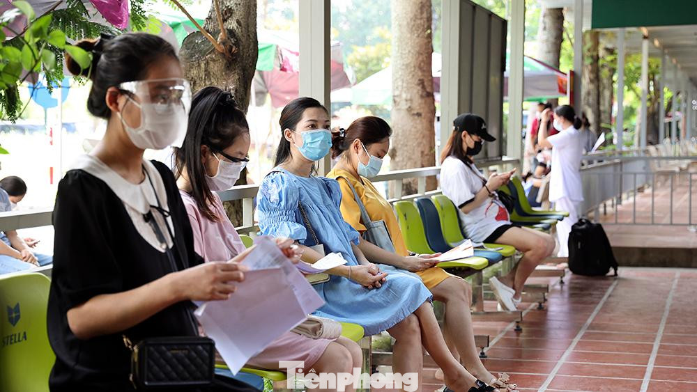 Các thai phụ đang ngồi chờ đợi tại khu vực khám sàng lọc trước khi tiêm.