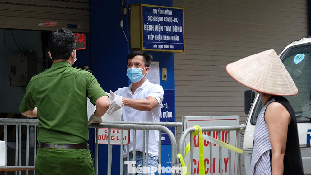 Lực lượng công an hỗ trợ nhân viên bệnh viện đưa thuốc ra ngoài sau khi được phun khử khuẩn cẩn thận hộp đựng thuốc.