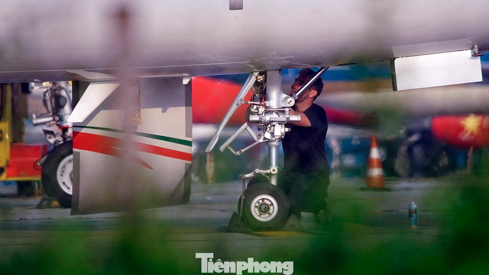 Kỹ sư kiểm tra hệ thống càng đỗ của máy bay trong sân bay Nội Bài.