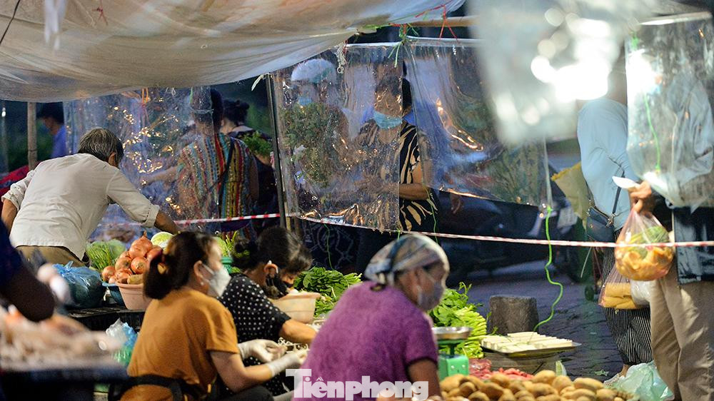 Tại một số khu chợ, bà con tiểu thương chủ động căng tấm chắn giọt bắn trong suốt để phòng chống dịch bệnh.
