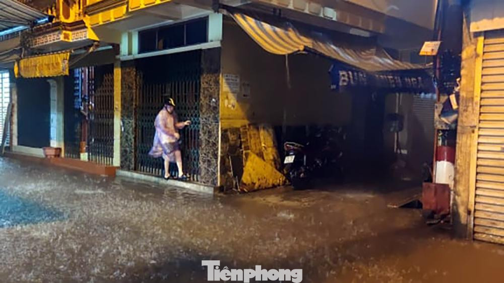 Phố ngập sâu khiến một số người phải đu cánh cửa sắt để đi lại Phố ngập sâu khiến một số người phải đu cánh cửa sắt để đi lại