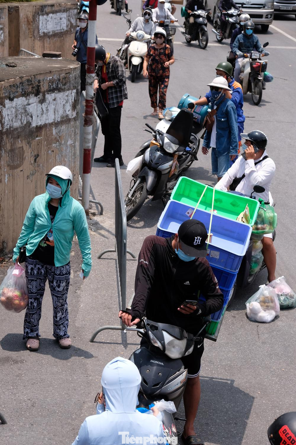 Dù giữa trưa nắng, ở chốt kiểm soát ở đầu phố Cầu Đất vẫn có rất nhiều người chuyên chở hàng hóa đến tiếp tế vào trong.