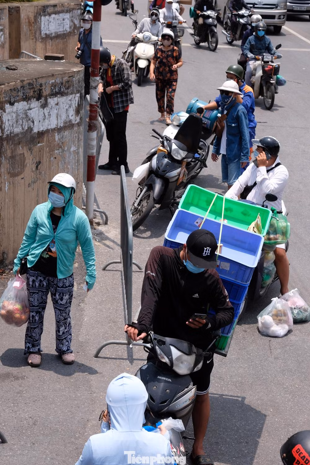Dù giữa trưa nắng, ở chốt kiểm soát ở đầu phố Cầu Đất vẫn có rất nhiều người chuyên chở hàng hóa đến tiếp tế vào trong.