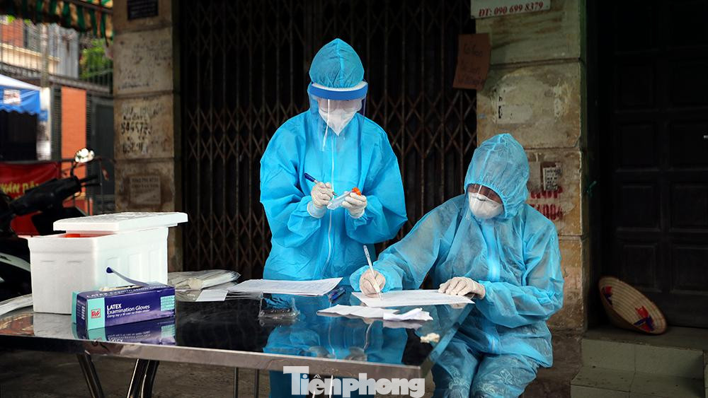 Tại một số điểm lấy mẫu khác, một số giáo viên cũng cùng tham gia vào việc ghi danh sách người dân đến lấy mẫu xét nghiệm.