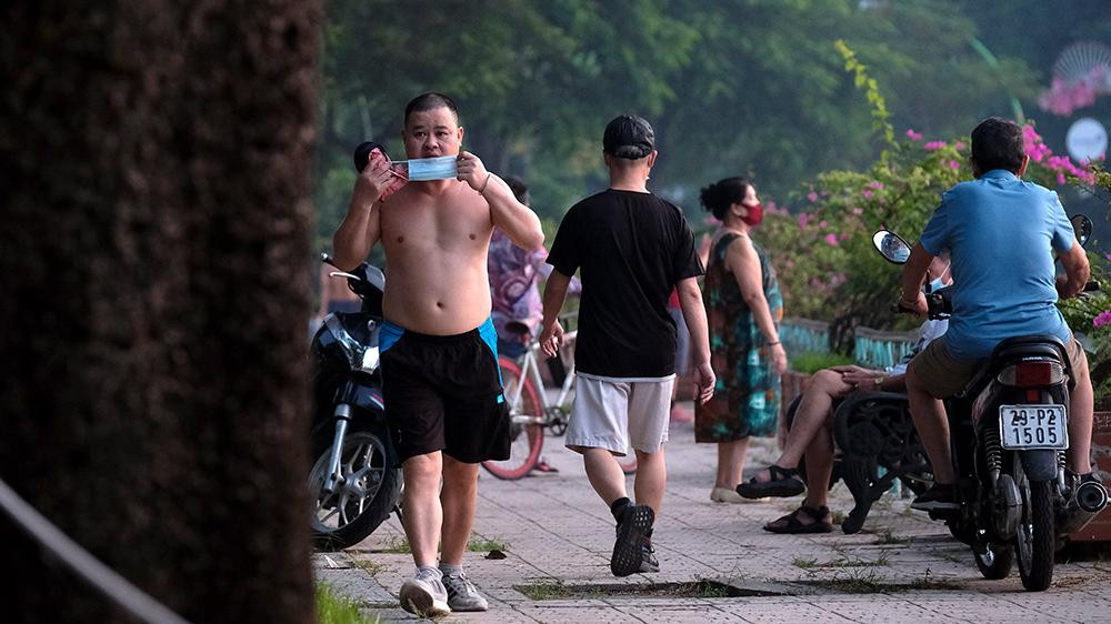 Thấy ống kính phóng viên, một số người vội vã đeo khẩu trang để đối phó, tránh bị ghi hình.