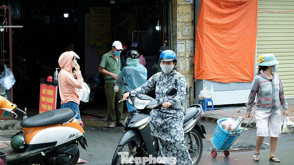 Người ra vào chợ được kiểm tra kỹ thẻ ra vào và khai báo y tế.