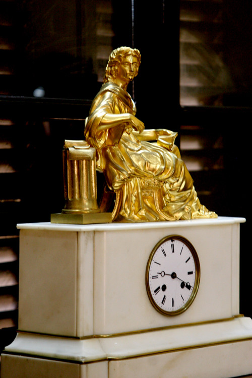 Một chiếc đồng hồ để bàn: Được làm bằng đá cẩm thạch trắng,mặt ngà, tượng đồng mạ vàng. Sản xuất tại Pháp, sản xuất những năm đầu thế kỉ XX)