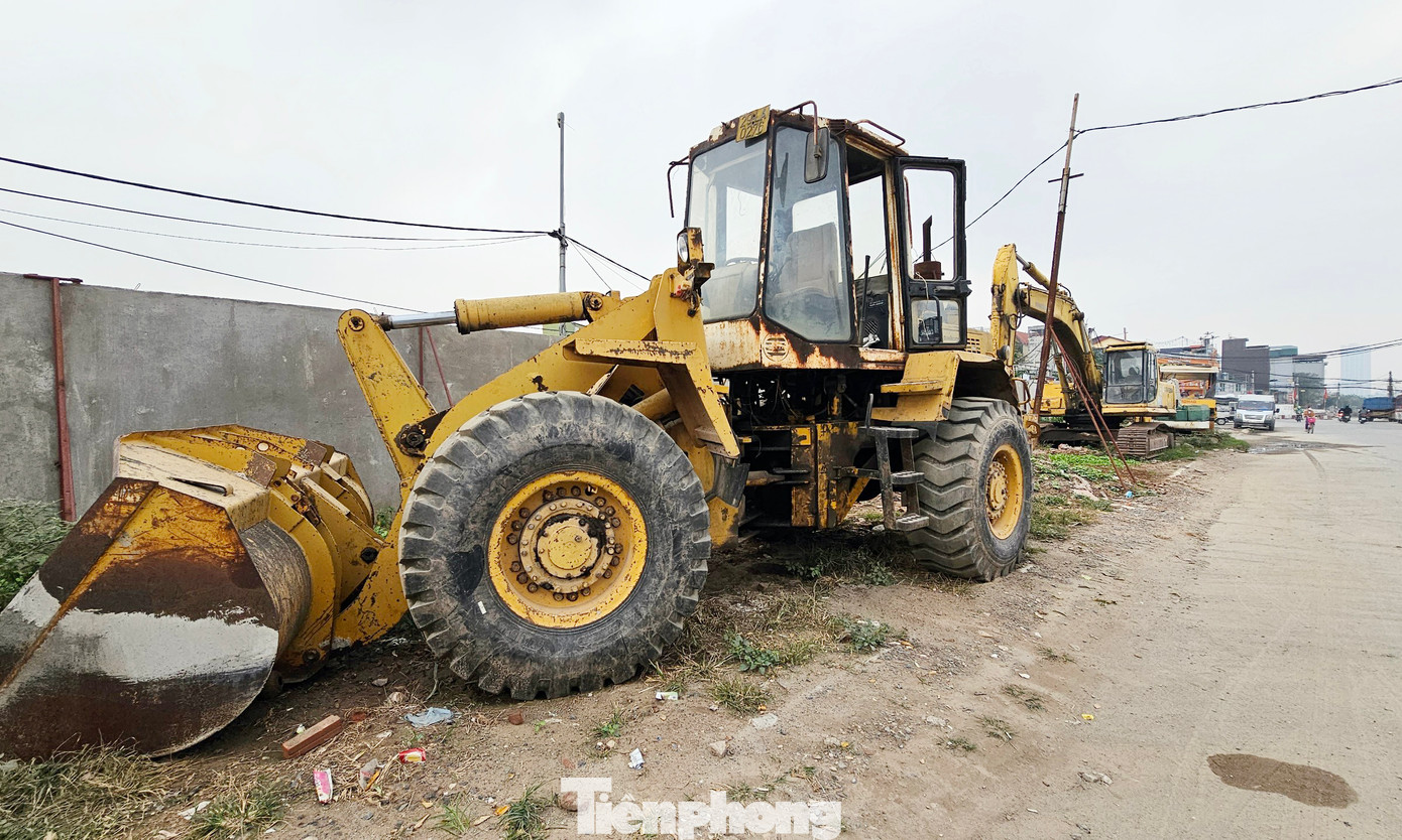 Máy móc thiết bị phục vụ thi công dự án đường Vành đai 2,5 xếp hàng dài bên đường và khu vực văn phòng điều hành.