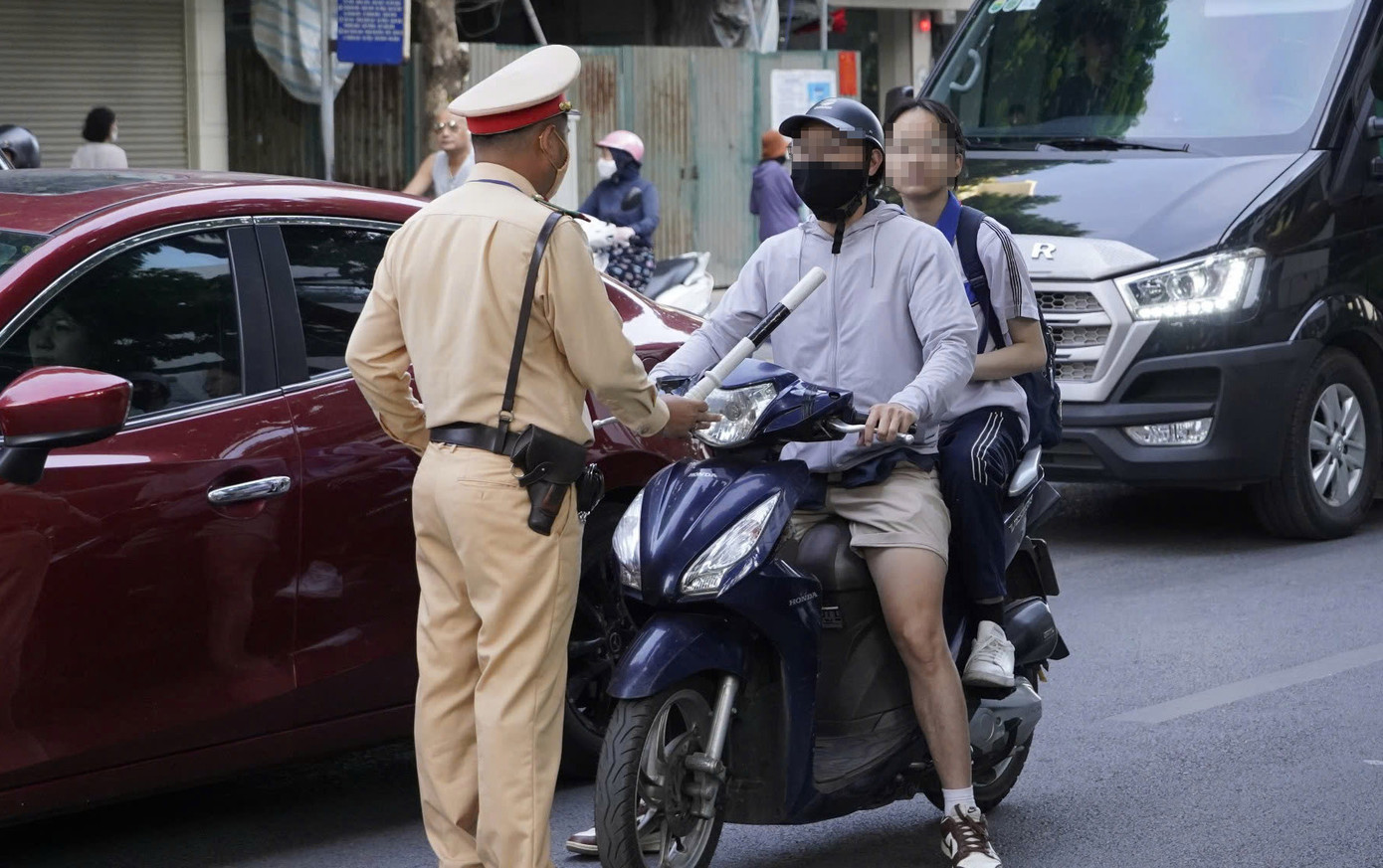 Nhiều phụ huynh vẫn chủ quan không đội mũ cho con khi tham gia giao thông.