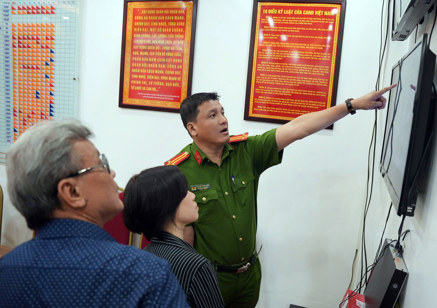 Trung tá Nguyễn Anh Tuấn giới thiệu, trao đổi với tổ dân phố, người dân về lợi ích xã hội hóa lắp camera. Ảnh: Công Hướng.