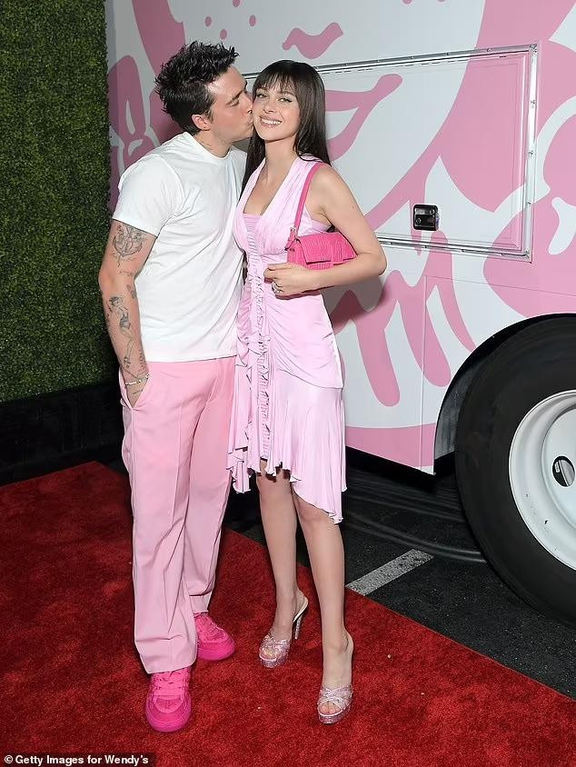 Cậu cả nhà Beckham cũng dành cho bà xã hơn 4 tuổi cái thơm má đầy tình cảm. Cặp đôi mới kết hôn hơn 4 tháng trước, vẫn đang trong thời kỳ mặn nồng nhất. Trong khi tình cảm đôi lứa thuận lợi, mối quan hệ giữa Nicola và mẹ chồng Victoria Beckham lại không mấy tốt đẹp. Kể từ sau đám cưới hồi cuối tháng 4, hai người không tương tác với nhau trên mạng xã hội. Theo tiết lộ của Nicola, hiểu nhầm giữa họ bắt nguồn từ việc Nicola không mặc váy cưới do mẹ chồng thiết kế.