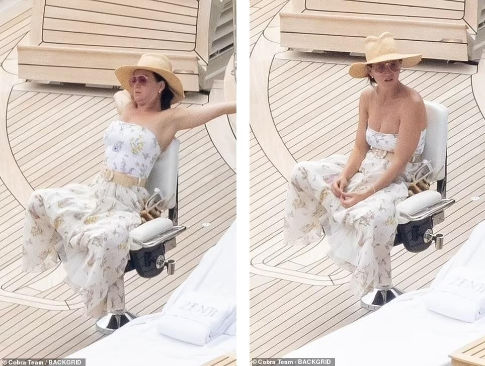 Katy tắm nắng trên boong thuyền. Cô biến áo tắm thành đồ mặc bình thường khi kết hợp thêm chân váy, thắt lưng và mũ rộng vành.