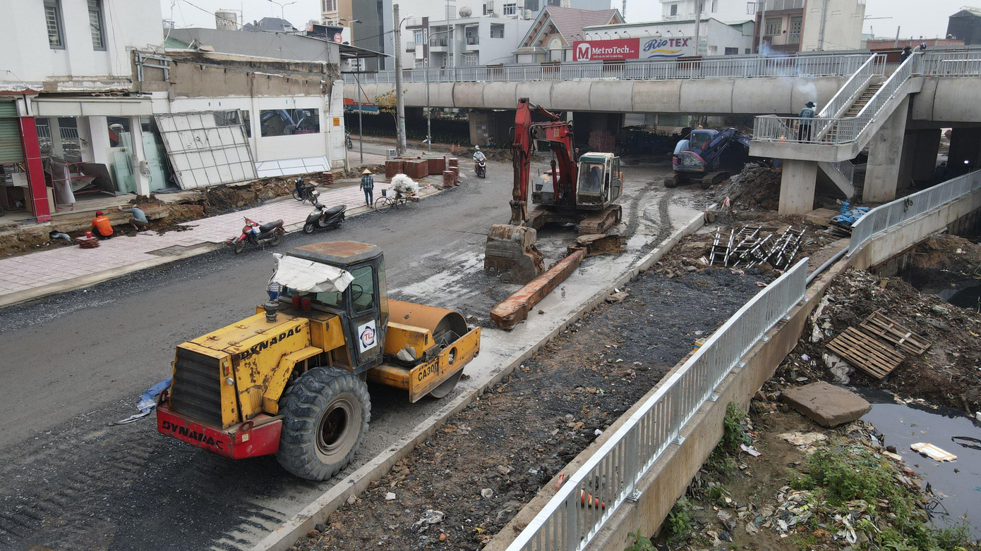 Con đường phía dưới cầu cũng đang được công nhân dùng thiết bị chuyên dụng để cào bóc lớp nhựa cũ, thay thế bằng lớp nhựa mới.