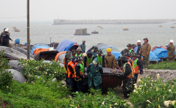 Bộ đội Hải quân và lực lượng phòng chống lụt bão địa phương giúp ngư dân đưa thuyền vào bờ tránh trú bão số 5