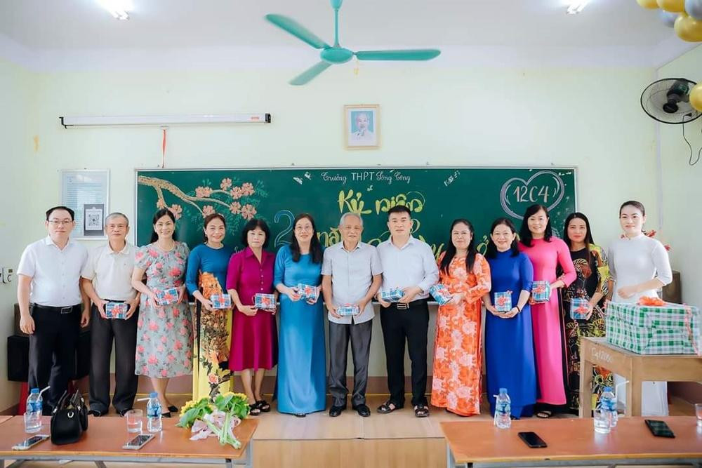 Hai đại diện lớp 12C4 (bìa trái và bìa phải) lên tặng quà lưu niệm cho các thầy cô trong buổi họp lớp sau 20 năm.