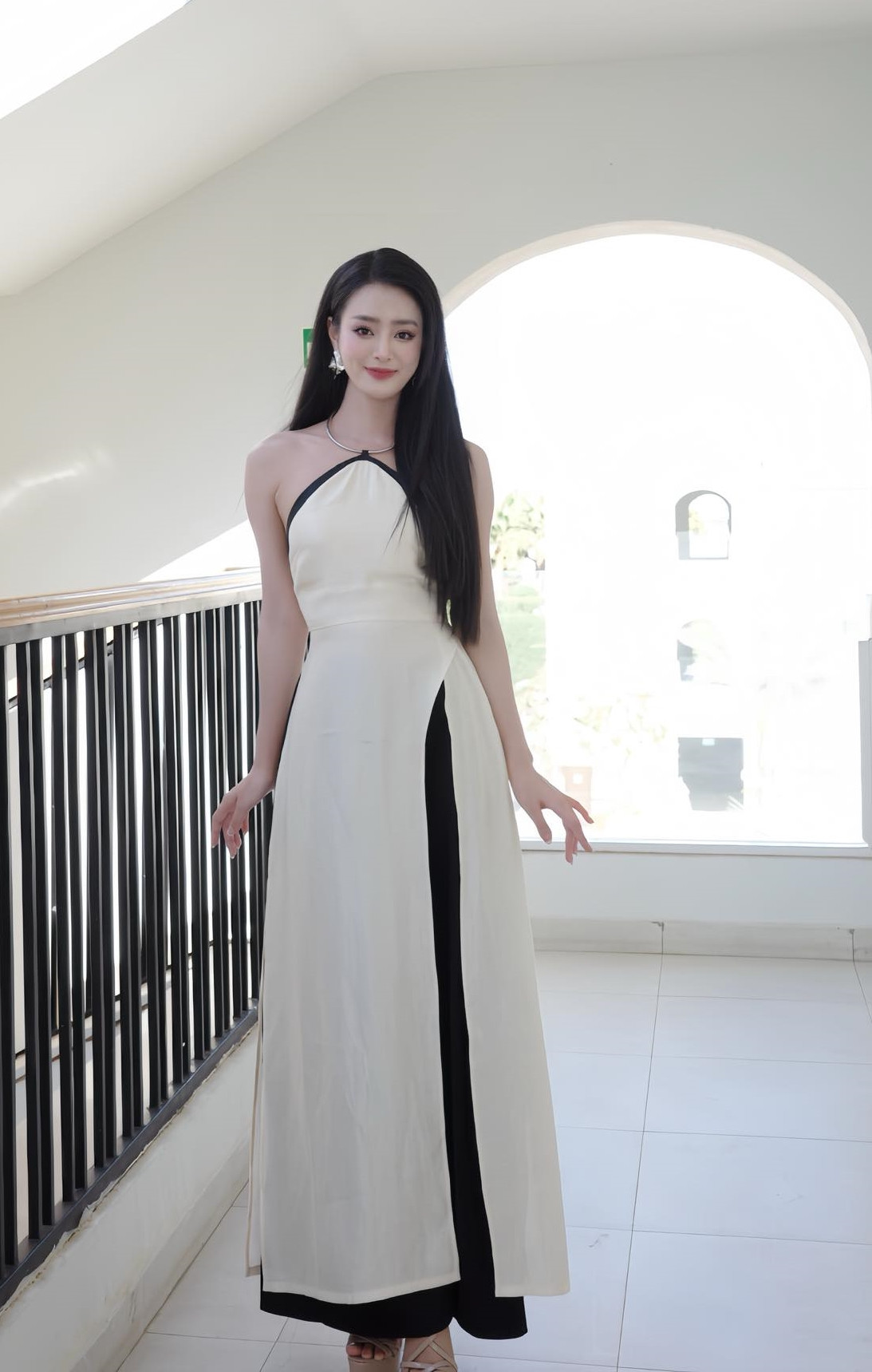 Bùi Khánh Linh mặc áo dài cách điệu trong một hoạt động.