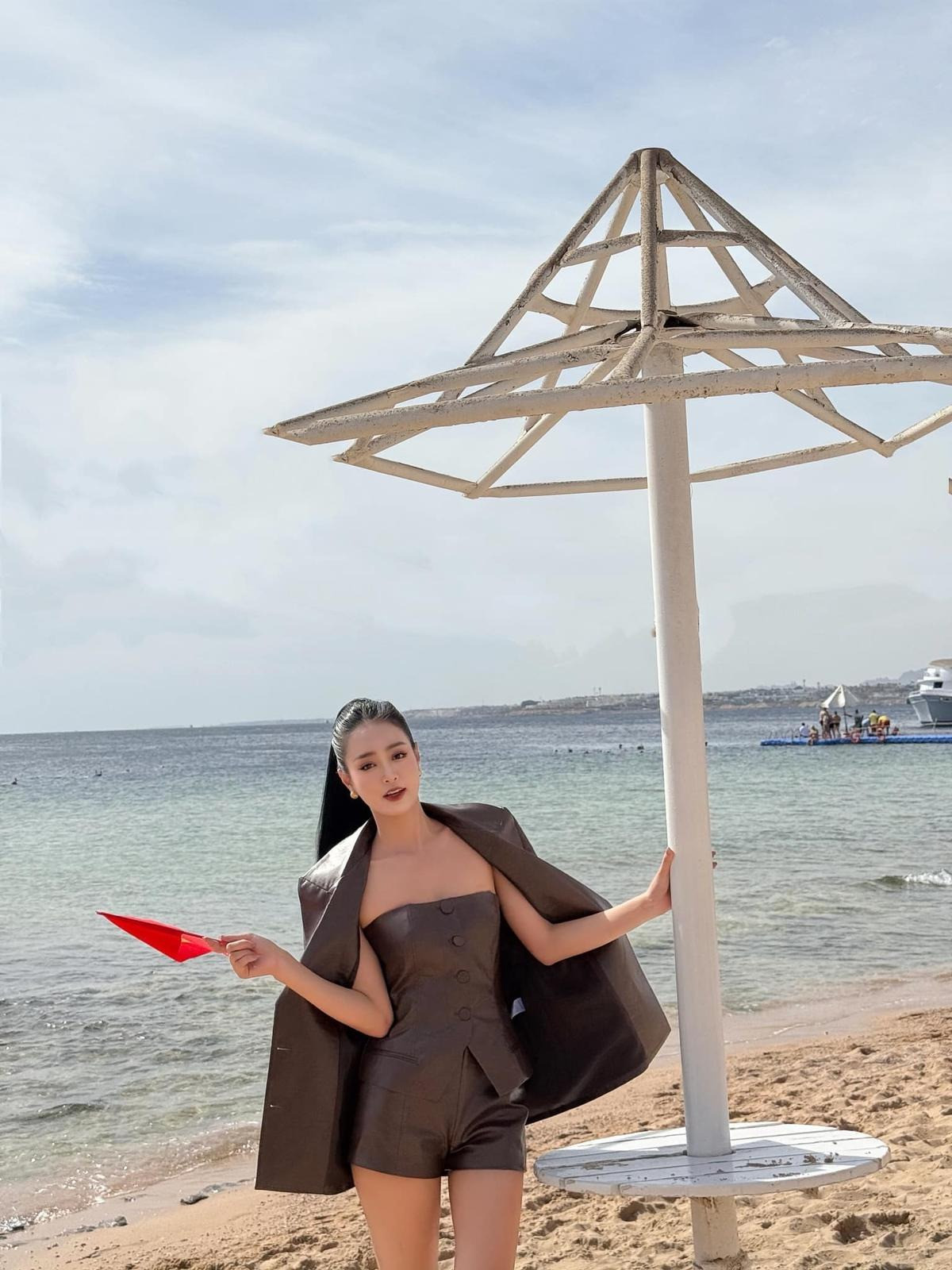 Bùi Khánh Linh cầm lá cờ nhỏ thay cho dải sash để khán giả có thể nhận diện.