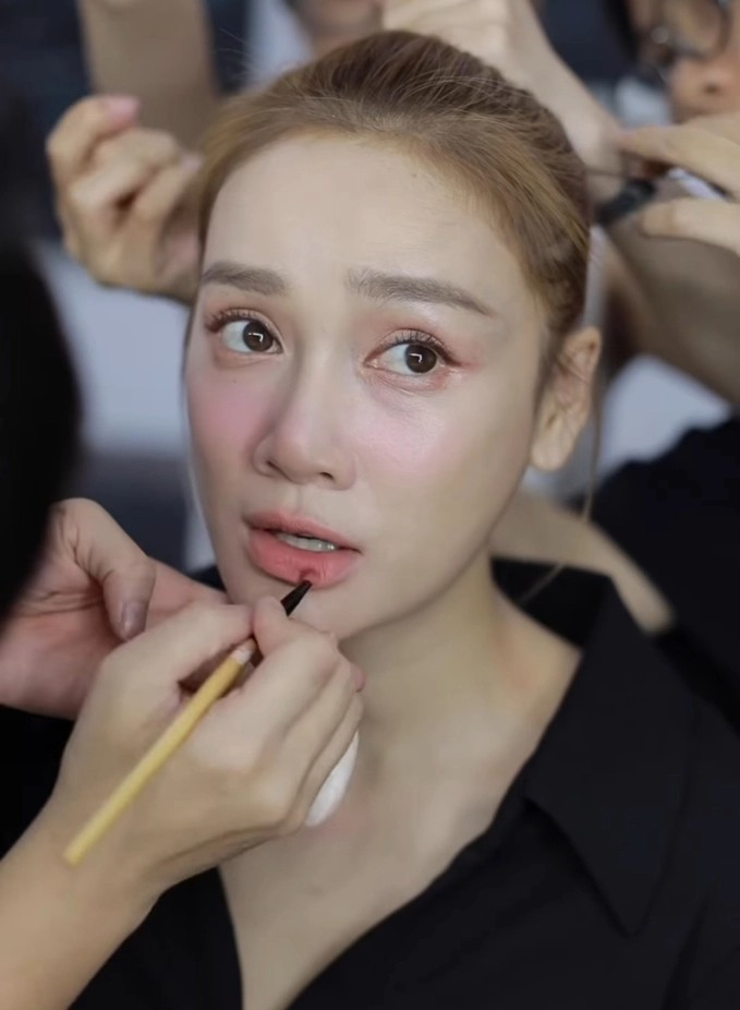 Nữ diễn viên trang điểm cẩn thận trước khi chạy.