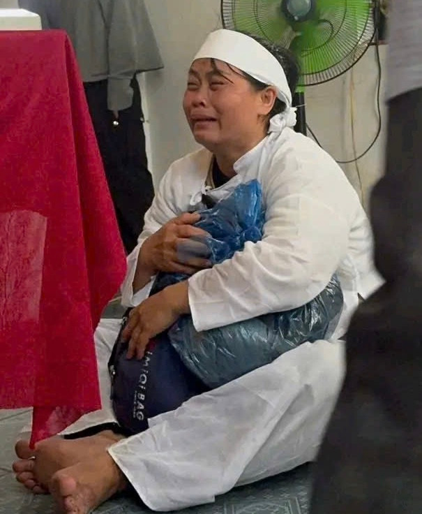 Vợ anh Nhân ôm di vật của chồng khóc ngất trước bàn thờ. Vợ anh Nhân ôm di vật của chồng khóc ngất trước bàn thờ.