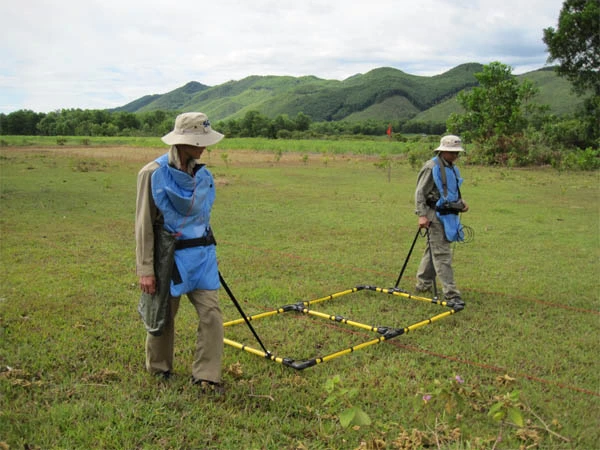 Kiểm tra các vùng đất khả nghi có bom mìn bằng các thiết bị tìm kiếm chuyên dụng. Ảnh: Trần Lam