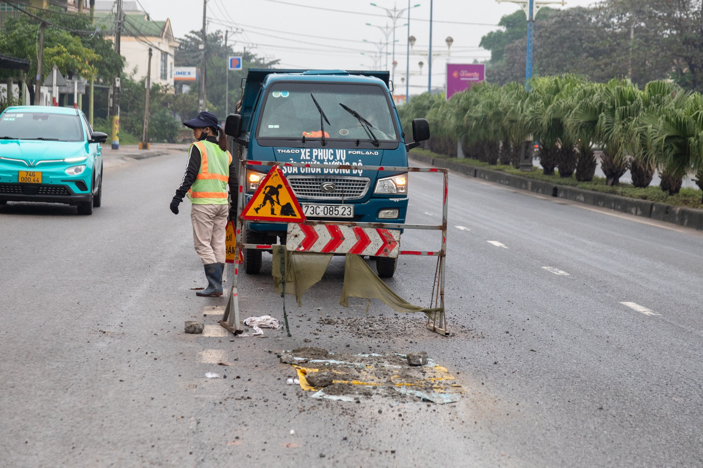 &quot;Ổ gà&quot; được vá tạm bằng xi măng, đậy lại bằng bao chờ khô cứng.
