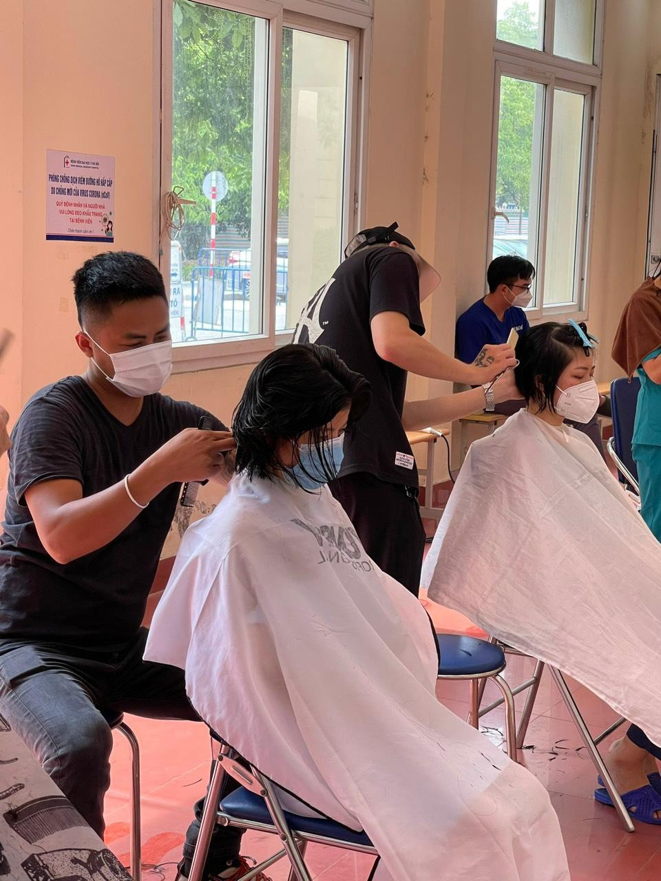 Đội tình nguyện đang cắt tóc cho các nữ y bác sĩ Đội tình nguyện đang cắt tóc cho các nữ y bác sĩ