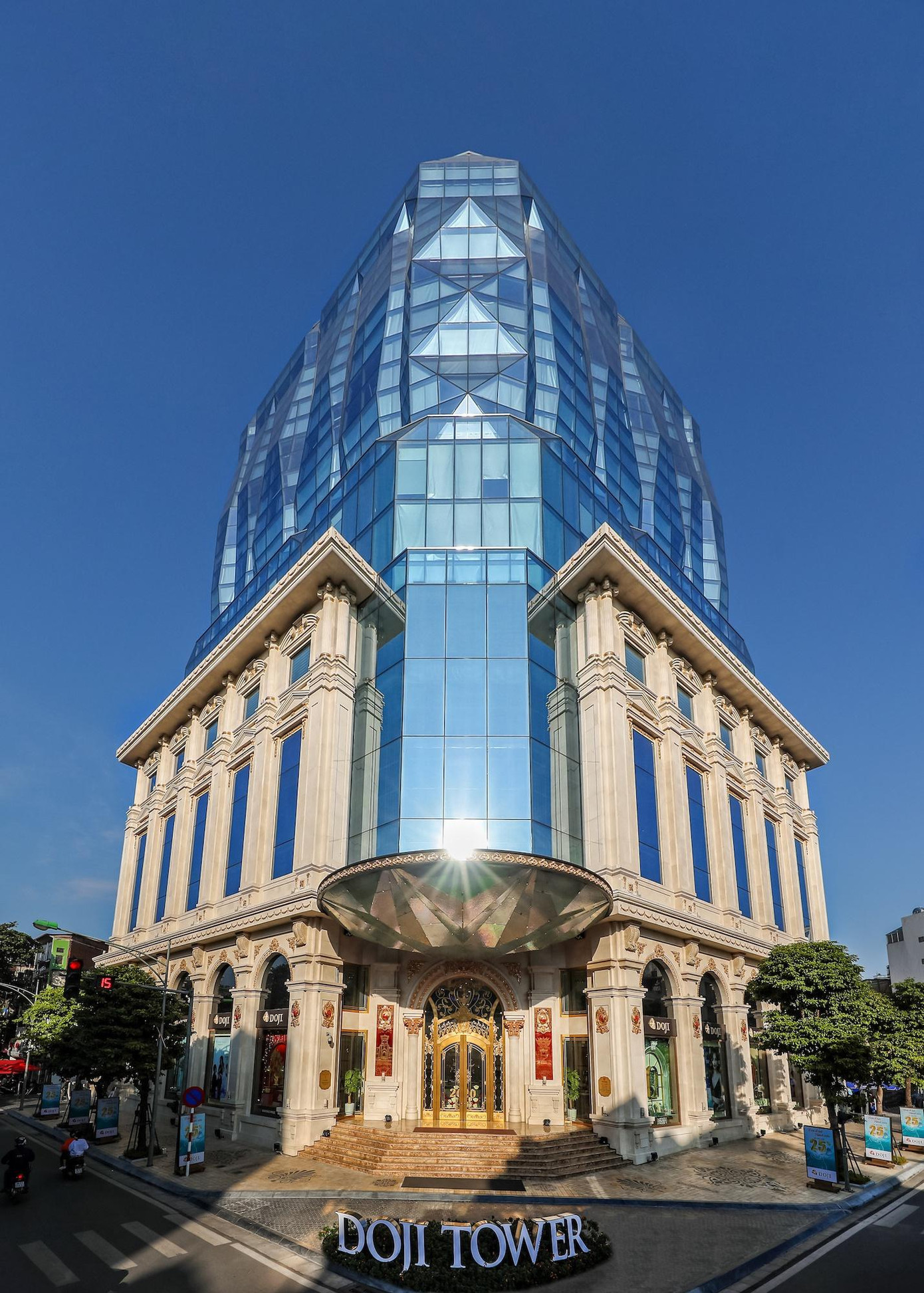 những công trình hiện đại ở Hà Nội ảnh 3 Doji Tower là một tòa nhà văn phòng hạng A tọa lạc ngay ngã tư Lê Duẩn - Nguyễn Thái Học. Công trình có quy mô 16 tầng nổi và 3 tầng hầm, trong đó mỗi mặt sàn rộng khoảng 600 m2. Điểm đặc biệt của tòa nhà là sử dụng các tấm kính phản chiếu ánh mặt trời, vừa giảm nhiệt của khu văn phòng, vừa tạo nên hiệu ứng ánh sáng lấp lánh như viên kim cương khổng lồ. Ban đêm, hệ thống đèn led hoạt động liên tục, tạo sự ấn tượng cho người đi đường.
