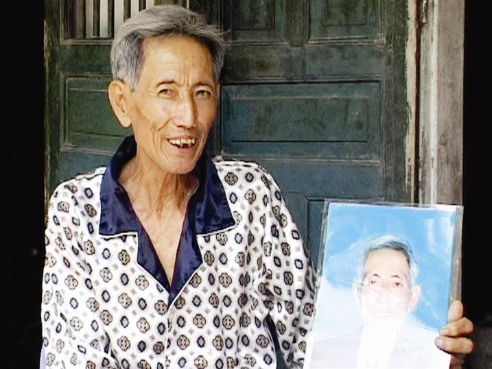 Ông Phan Văn Thức bên bức ảnh “thờ hụt” của mình. Ảnh: Minh Hiếu