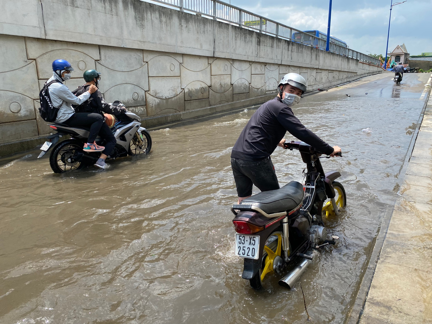 Người dân bì bõm đưa phương tiện thoát ra điểm ngập úng. Ảnh: CTV Người dân bì bõm đưa phương tiện thoát ra điểm ngập úng. Ảnh: CTV