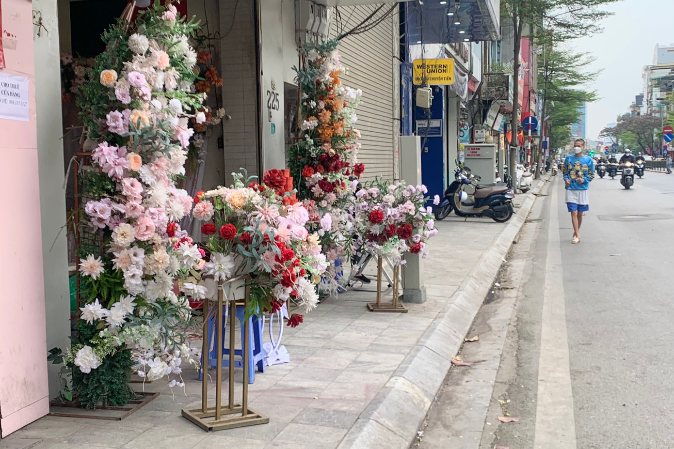 Một cửa hàng bày bán sản phẩm hết vỉa hè, người đi bộ không còn chỗ mà đi.