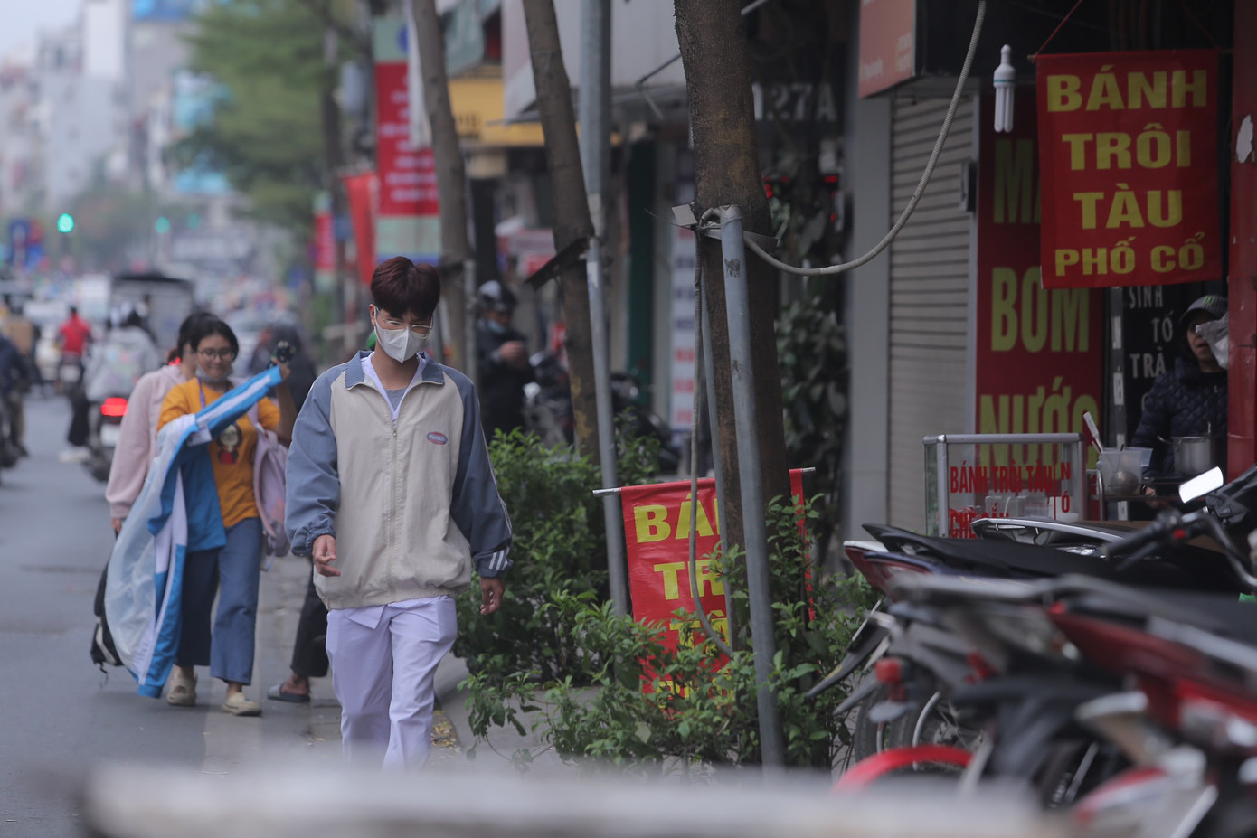 Vỉa hè phố Tây Sơn (quận Đống Đa, Hà Nội) chật cứng các phương tiện xe máy đỗ khiến người đi bộ phải đi dưới lòng đường.