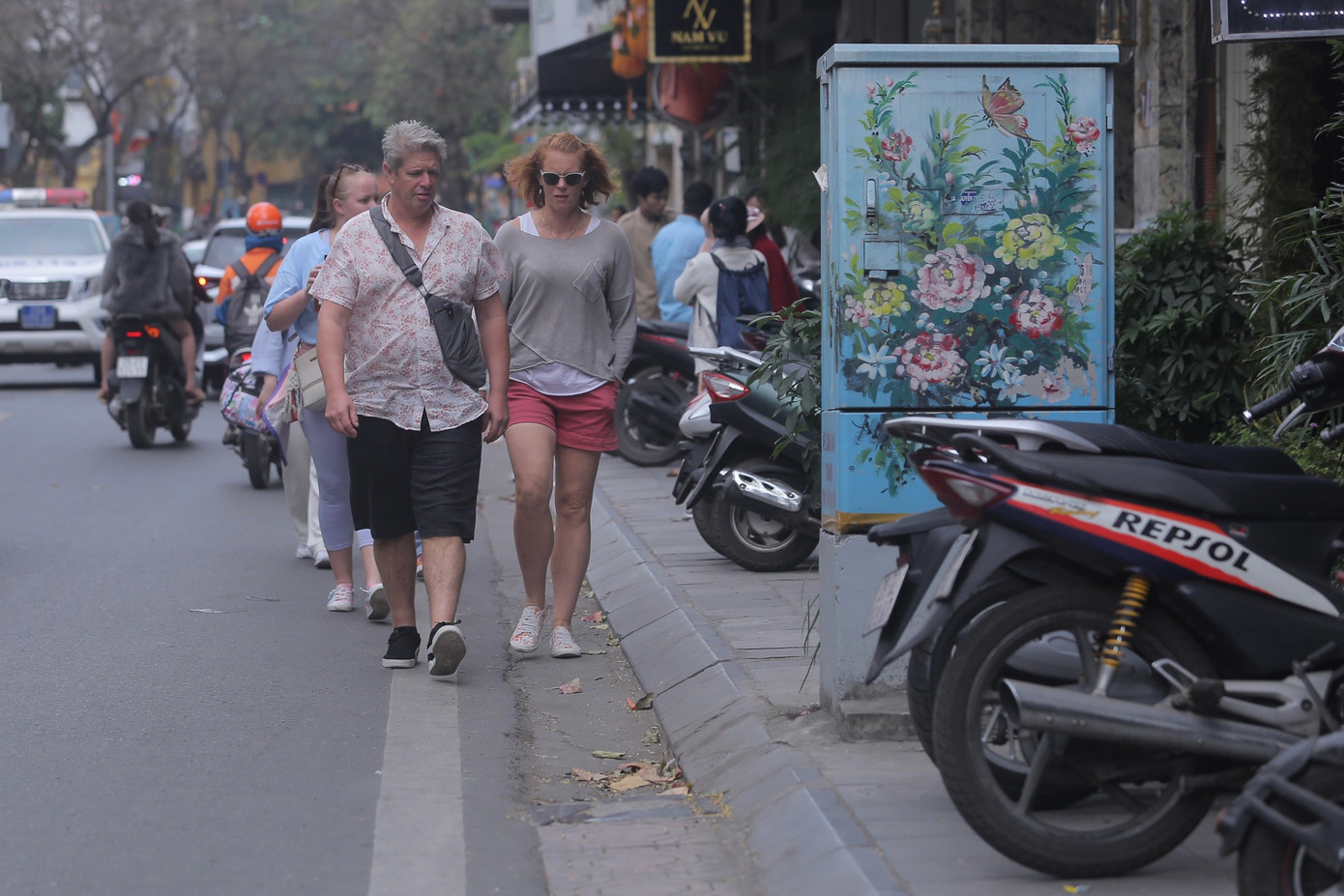 Du khách quốc tế buộc phải đi bộ dưới lòng đường khi vỉa hè bị chiếm dụng.