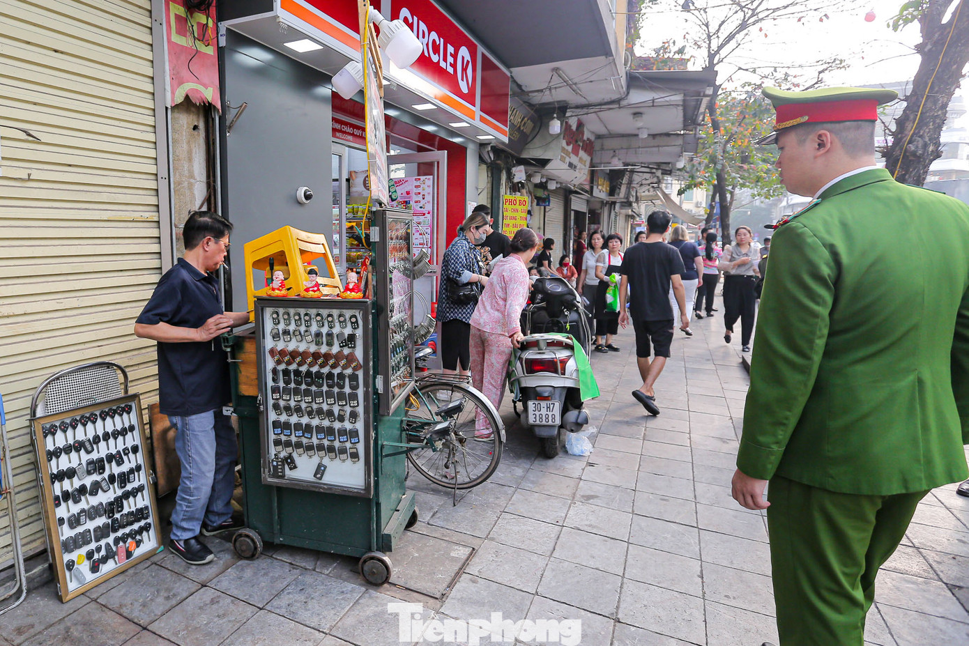 Các hộ kinh doanh thu dọn lại hàng hóa bày bán trên vỉa hè khi thấy lực lượng chức năng.